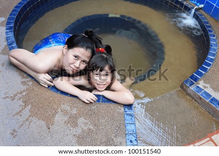 Adorable girl and her mother in hot spring water pool