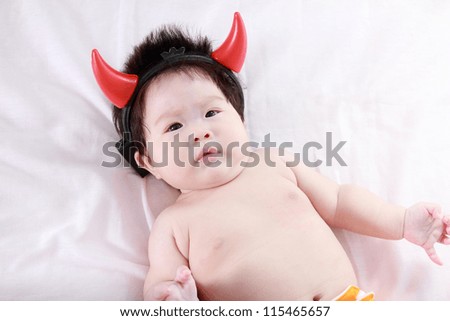 Adorable newborn baby with devil horn