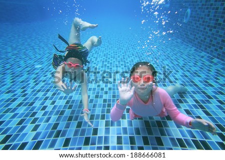 little asian girl underwater in swimming pool