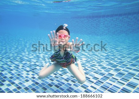 little asian girl underwater in swimming pool