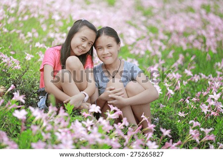 two girlfriends having fun in flower field