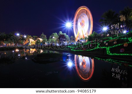 Ferris wheel at night view with water reflection