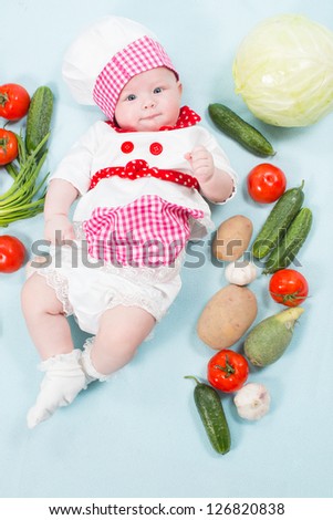 Baby girl  wearing a chef hat with vegetables. Use it for a child, healthy food concept