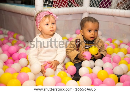 Happy children in colored ball on birthday on playground. The concept of childhood and holiday