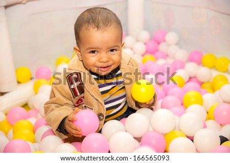 Happy black boy in colored ball on birthday on playground. The concept of childhood and holiday