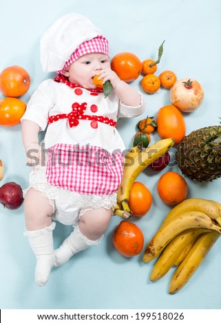 Baby cook girl wearing chef hat with fresh fruits. Use it for a child, healthy food concept