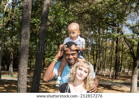 African American happy family: black father, mom and baby boy on nature. Use it for a child, parenting or love concept
