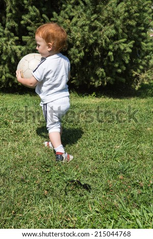 Adorable little child boy with soccer ball in park on nature at summer. Use it for baby, parenting or love concept