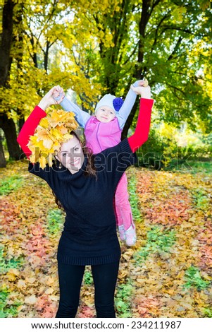 Happy mom and child girl hugging on nature at  fall. The concept of childhood and family. Beautiful Mother and her baby outdoor