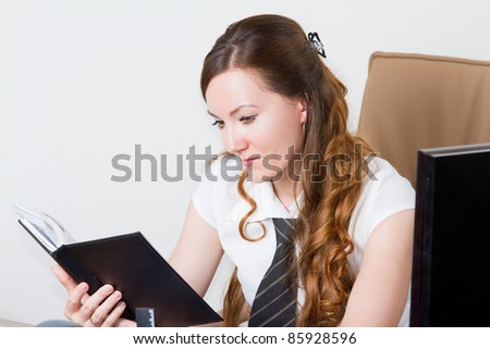 Serious manager woman read the notes in a notebook at a desk in the office