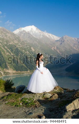 The sexy russian beautiful woman the bride in a wedding dress on mountain
