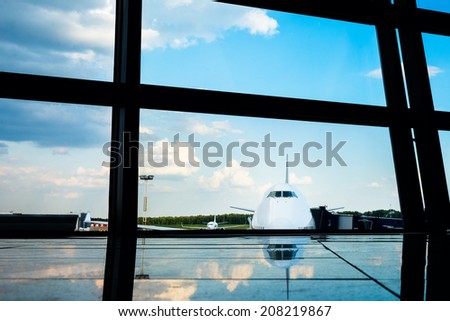 Jet aircraft behind airport windows. With reflection on the floor.