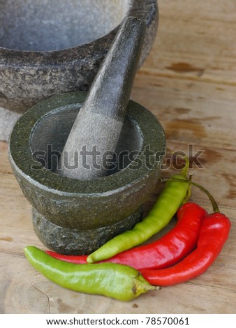 Stone mortar and pestle with chili