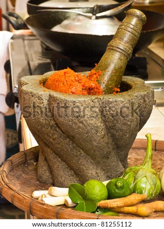 Stone mortar and pestle with red curry ingredient