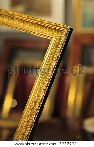 lovely antique gold frame in an antique shop with more frames in the background
