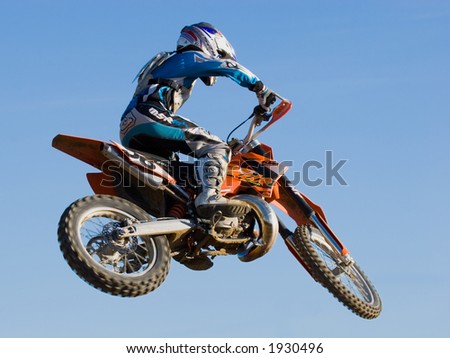 Motorcycle jumping viewed from beneath.