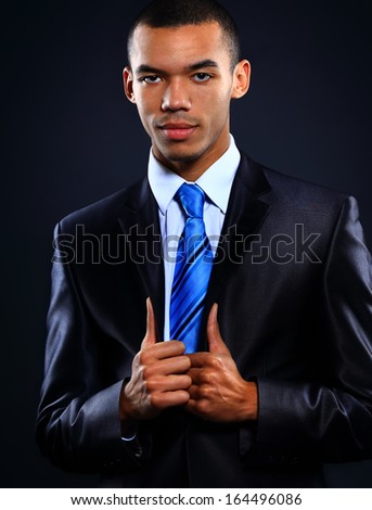Portrait of African American businessman with arms together isolated over dark background