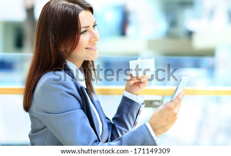 Cafe city lifestyle woman on phone drinking coffee texting text message on smartphone app sitting indoor in trendy urban cafe