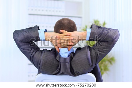 Rear view of businessman with hands behind head