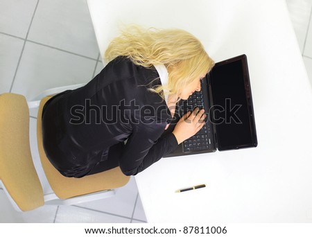 Young businesswoman in black suit sleeping on the laptop. Top view.