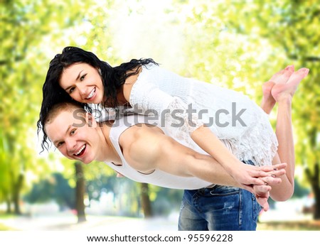 Portrait of loving couple enjoying together while piggyback ride outdoors