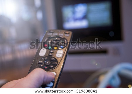Man watching television using TV remote