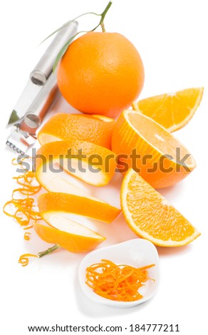 Orange zest in white bowl, peel, orange fruit and  utensils for zesting,  isolated over white.