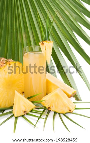 Pineapple juice in a glass,  slices of pineapple and  green palm leaf. Isolated on white.