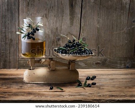 Weighing fresh olives and olive oil on vintage scales, with space for text on a wooden old background