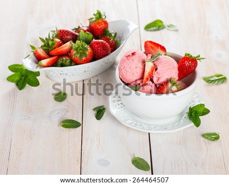 Dessert or ice cream, made from fresh berries with fresh strawberries on a light wooden surface. Selective focus.