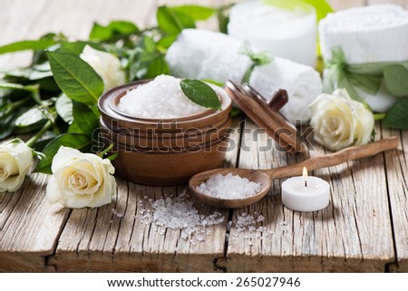 Spa concept with white roses,sea salt and candle on wooden background