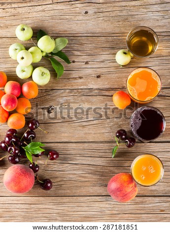 Glasses of tasty fresh juice and summer fruits on a old wooden table, overhead view