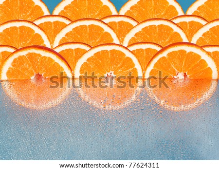 Orange slices  reflected in drops on a blue background