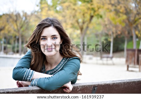 Pretty Blue Eyed Woman Grinning with Fall Trees in Background