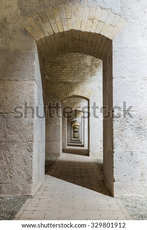 Castle tunnel interior with a series of symmetric arches in a bastion fortress.