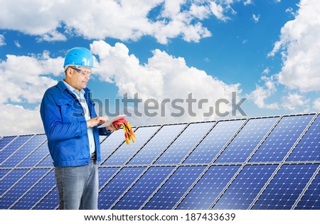 engineer with tablet pc installing solar panels
