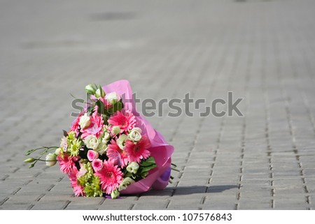 Bridal bouquet of flowers lay on the sidewalk