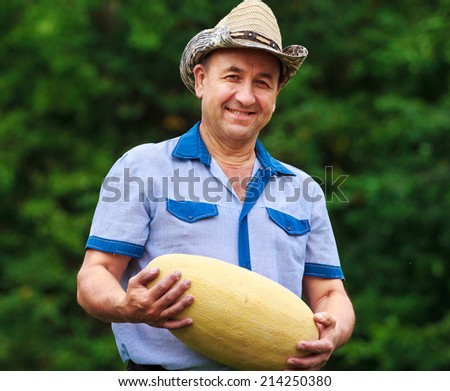 Happy gardener with melon in hands