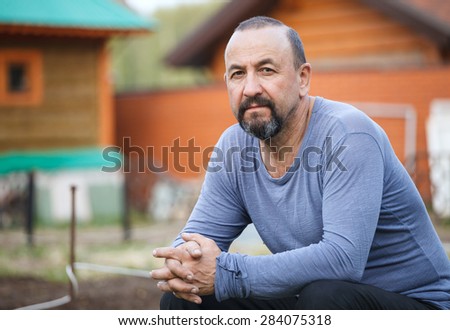 Portrait of happy middle aged smiling man in a countryside