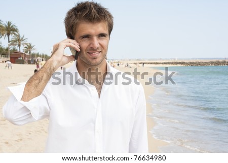 young businessman talking on the mobile phone at the beach
