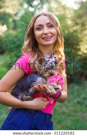 Portrait of beautiful smiling young woman with small dog outdoor