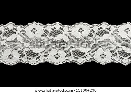Lace trim ribbon over white. Embroidered fabric