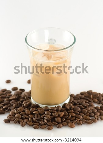 Glass of ice coffee with ice cube and coffee beans around