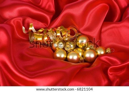 Gold christmas balls on the red satin background