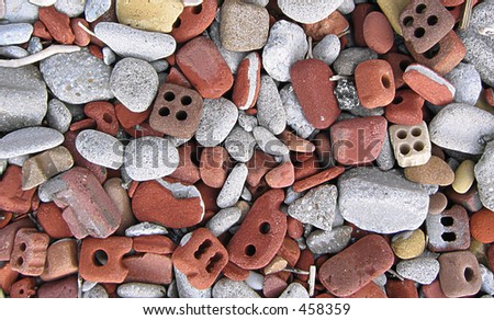 bricks and rocks on a lakeshore, rounded and rolled by the beat of waves on a beach