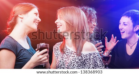 Cheerful friends having conversation and enjoying in the nightclub.