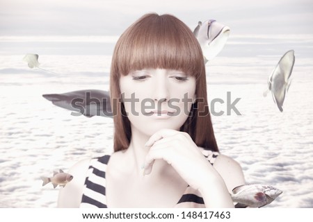 Photo compilation of beautiful woman daydreaming and around her are swimming fish. In the clouds.