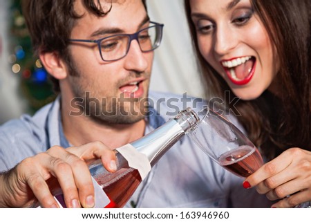 Young happy couple drinking champagne on New Year\'s eve.