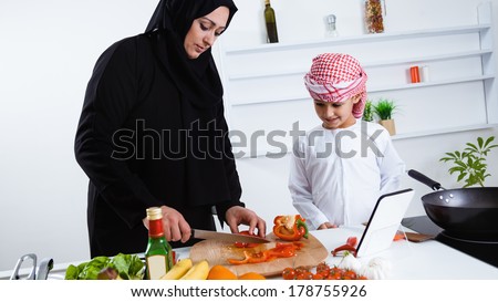 Happy Arabic child in the kitchen with his mother
