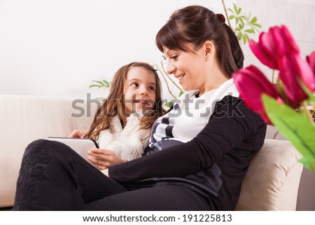 Cute little girl and her mother for Mother\'s day. Focus is on flowers.